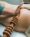 Beautician performing wood therapy treatment with a roller with pins on the buttock of the patient.