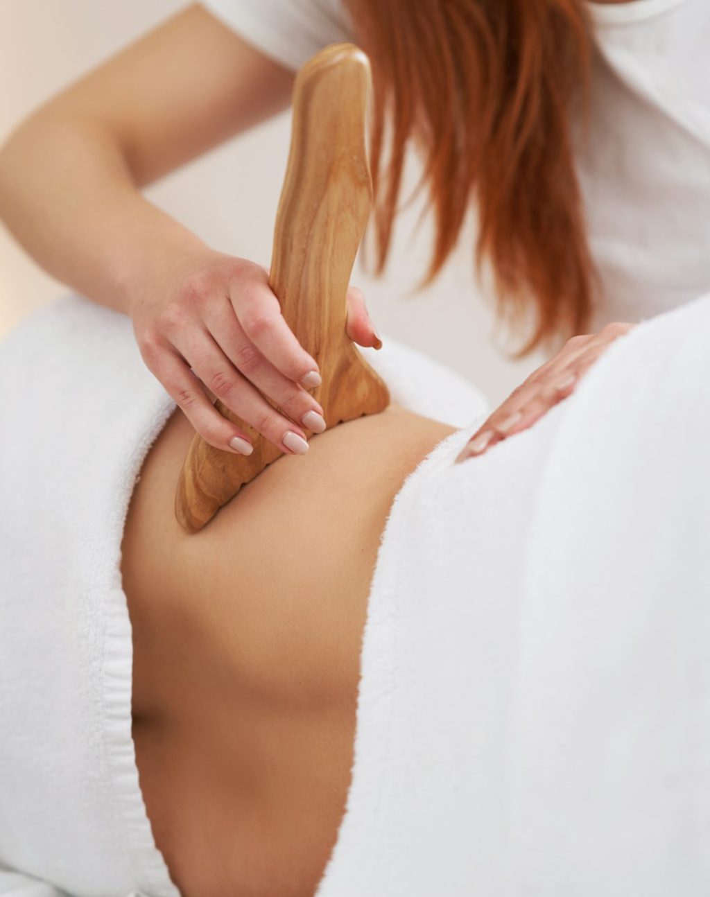 Woman at massage therapy with wooden tools